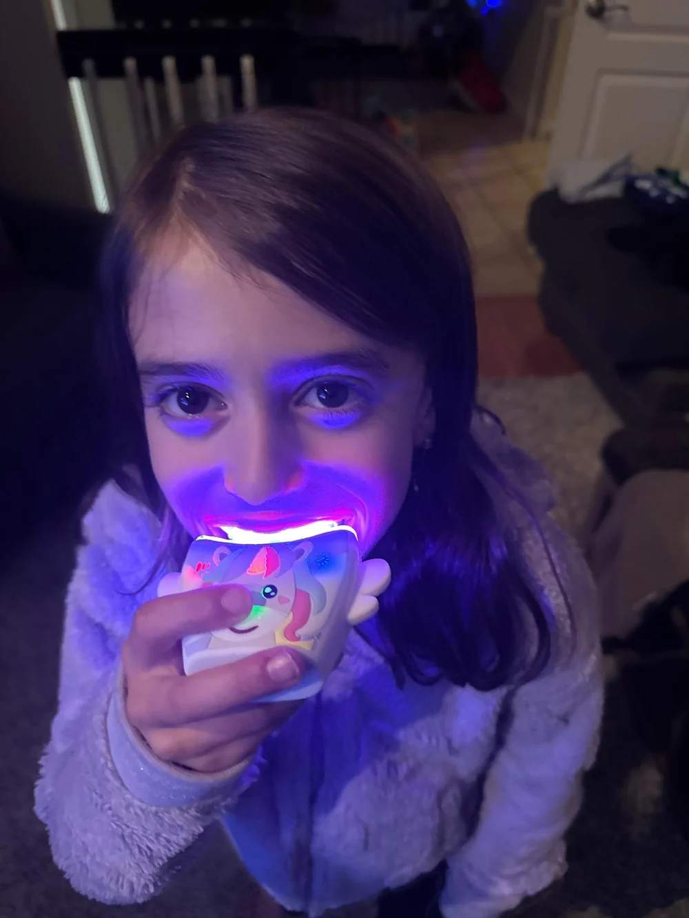 A child brushing with the unicorn Kids 360° sonic brush glowing in her mouth
